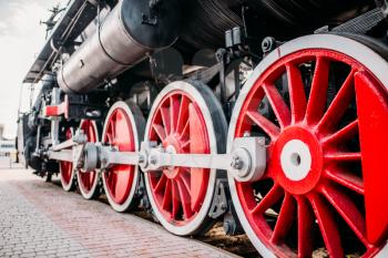 Old steam train, red wheels closeup. Vintage locomotive. Railway engine, ancient railroad vehicle