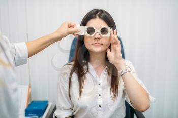 Female patient on diagnostic of vision, professional choice of glasses lens. Eyesight test in optician cabinet. Consultation with oculist, ophthalmology