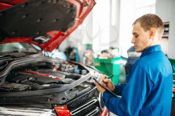 Technician with notebook fills the check list, car with opened hood, fixing the problems. Automobile service, vehicle maintenance