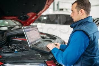 Engineer makes computer diagnostics of the car in auto-service. Vehicle wiring inspection