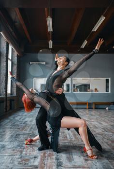 Two elegance dancers in costumes on ballrom dance training in class. Female and male partners on professional pair dancing in studio