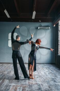 Elegance man and woman on ballrom dance training in class. Female and male partners on professional pair dancing in studio