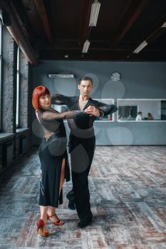 Elegance couple on ballrom dance training in class. Female and male partners on professional pair dancing in studio
