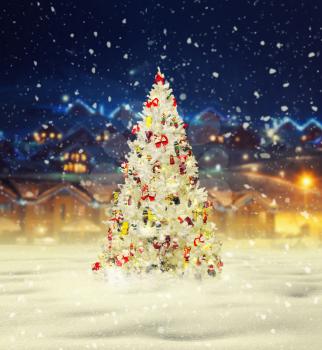 Merry christmas, snowy xmas tree with decoration, village on background, new year. Winter holiday celebration