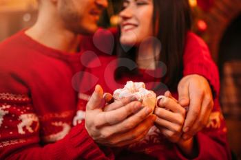 Love couple warm hands on a Cup of coffee, romantic xmas celebration. Christmas holidays, man and woman happy together, festive decoration on background