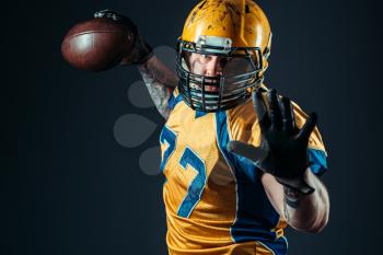 American football offensive player with ball in hand, national league, black background. Contact sport