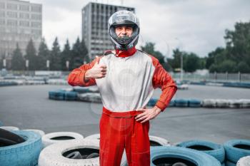 Kart driver in helmet, karting track on background. Go-kart motor sport