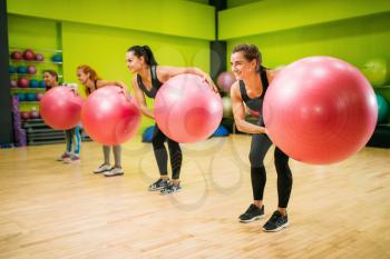 Women group with big balls doing exercise, fitness workout. Female sport teamwork in gym. Fit class, aerobic