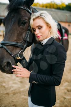 Portrait of blonde woman with horse, horseback riding. Brown stallion, leisure with animal, equestrian sport