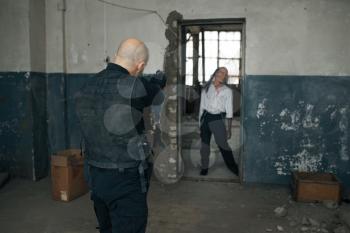 Man shoots zombie, nightmare in abandoned factory, bullet effect. Horror in city, creepy crawlies, doomsday apocalypse