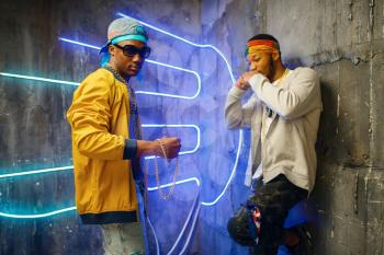 Two black rappers, neon lights on background. Rap performers in subway, underground lifestyle, urban style