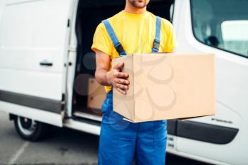 Male person in uniform holds cardboard box in hands, distribution business. Cargo delivery. Empty, clear container