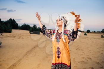 American Indian woman hands up, ritual, ritualistic ceremony Cherokee, Navajo reservation people. Headdress made of feathers of wild birds