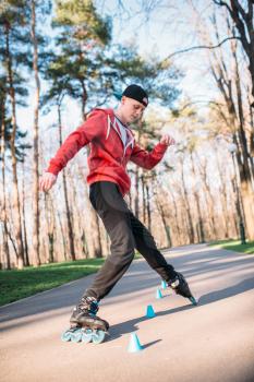 Roller skater, rollerskating trick exercise in park. Male rollerskater leisure