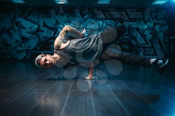 Hip hop action, male dancer motions in dance studio. Modern urban dancing style