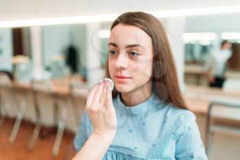 Applying make-up on beautiful girl face, beauty studio on background. Cosmetic salon