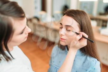 Make up artist work with woman eyes, beauty studio on background. Cosmetic salon