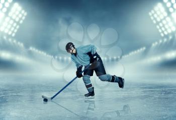 Professional ice hockey player in equipment poses on stadium. Ice-skating. Winter season sport