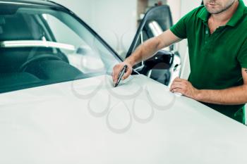 Mechanic prepares car protect coating against chips and scratches. Automobile paint protection film installation process. 