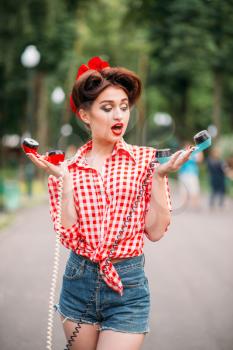 Glamour pin up girl with retro rotary telephones, vintage american fashion. Attractive woman in pinup style