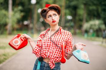Glamour pin up girl with retro rotary telephones, vintage american fashion. Attractive woman in pinup style