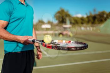 Male tennis player hand with racket and ball, outdoor court. Summer season active sport game
