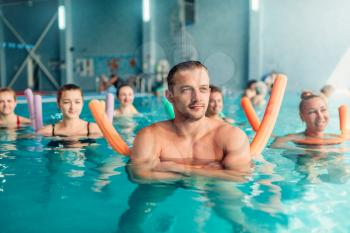 Aqua aerobics traninig. Women group, male trainer. Indoor swimming pool