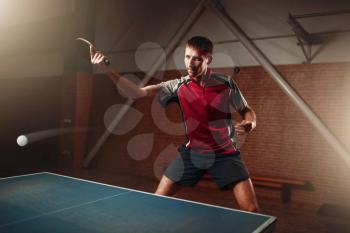 Table tennis, male player with racket in action, ball with trace. Ping pong training indoor