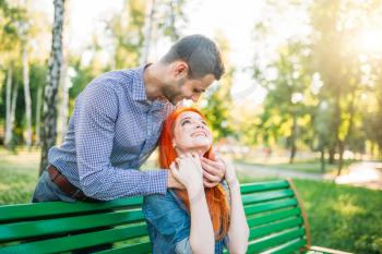 Romantic date of love couple in summer park. Man closed the woman's eyes