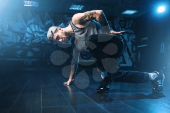 Breakdance motions, performer in dance studio. Modern urban dancing style