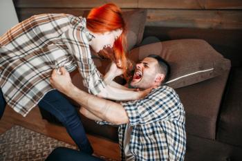 Angry wife beats her husband, domestic violence, quarrel, agressive couple fight. Man and woman in conflict. Problem relationship