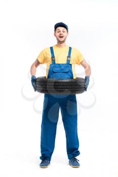 Tire service, handyman in blue uniform, white background, repairman, wheel mounting