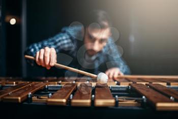 Xylophone player with sticks in hands, musician in action, wooden sounds. Musical percussion instrument, vibraphone