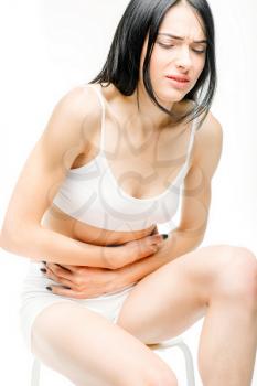 Abdominal pain, female person with stomach problem, white background. Woman in white lingerie, medical advertising or concept