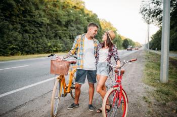 Young man and woman kissing on romantic date. Happy love couple with vintage bike. Boyfriend and girlfriend together outdoor, retro bicycle