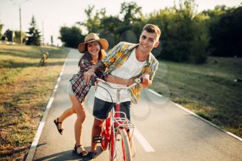 Love couple fun together in summer park, vintage bicycle, romantic date of young man and woman. Boyfriend and girlfriend together outdoor, retro bike