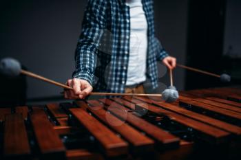 Xylophone player hands with sticks, wooden sounds. Musical percussion instrument