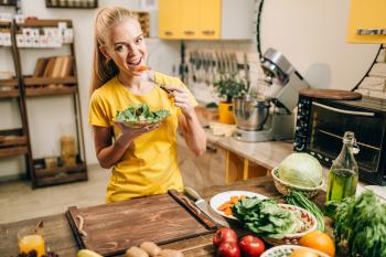 Young woman eating on the kitchen, healthy eco food. Vegetarian diet, fresh vegetables and fruits