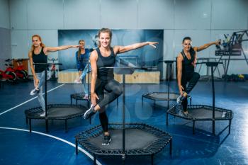 Women group doing fit exercise on sport trampoline, fitness workout. Female teamwork in gym. Aerobic class
