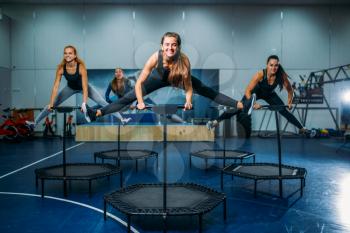Women group on sport trampoline, fitness workout. Female teamwork in gym. Aerobic class