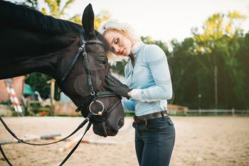 Woman hugs her horse, friendship, horseback riding. Equestrian sport, young woman and beautiful stallion, farm animal