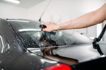 Male specialist work with window, car tinting film installation process, installing procedure,