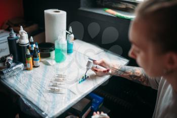Female tattoo artist prepares color ink. Preparation for tattooing, tattoo salon