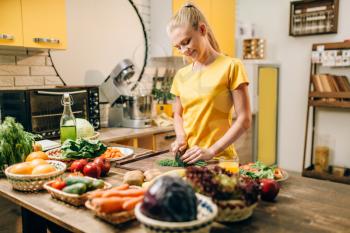 Housewife cooking on the kitchen, healthy organic food preparation. Vegetarian diet, fresh vegetables and fruits on wooden table