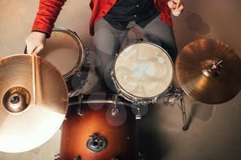 Drummer in red suit, top view, vintage style. Musical performer, drum instrument, live music concert