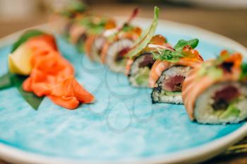 Sushi rolls with salmon fish on plate closeup. Traditional oriental food, japanese kitchen, asian cuisine