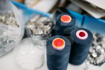 Black threads on spools closeup, sewing material, yarn on bobbins macro, tailoring or dressmaking equipment