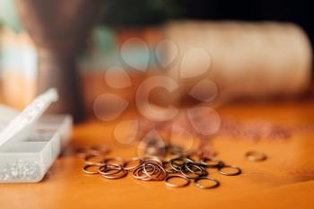 Little metal rings on wooden table, closeup. Handmade jewelry. Needlework, bijouterie making