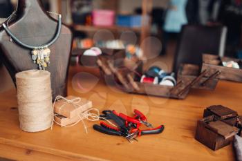 Needlework equipment and tools, pliers, workshop interior. Handicraft accessories. Handmade fashion jewelry, bijouterie