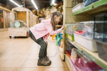 Little girl plays with hamster in pet shop. Petshop advertising concept